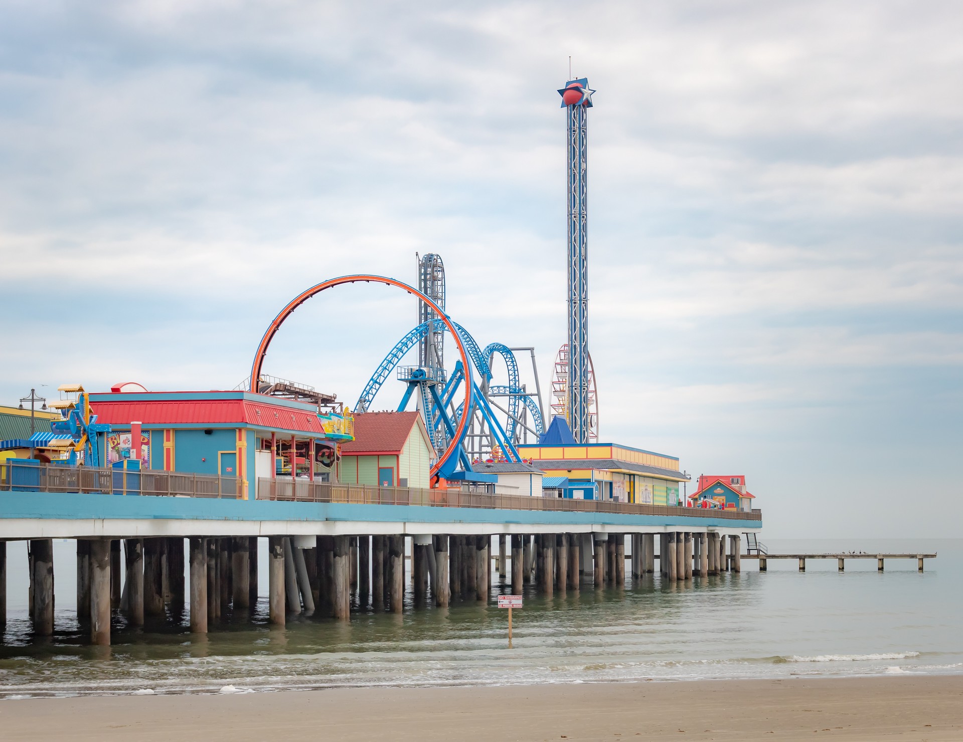 Amusement park boardwalk and carnival rides along the beach.