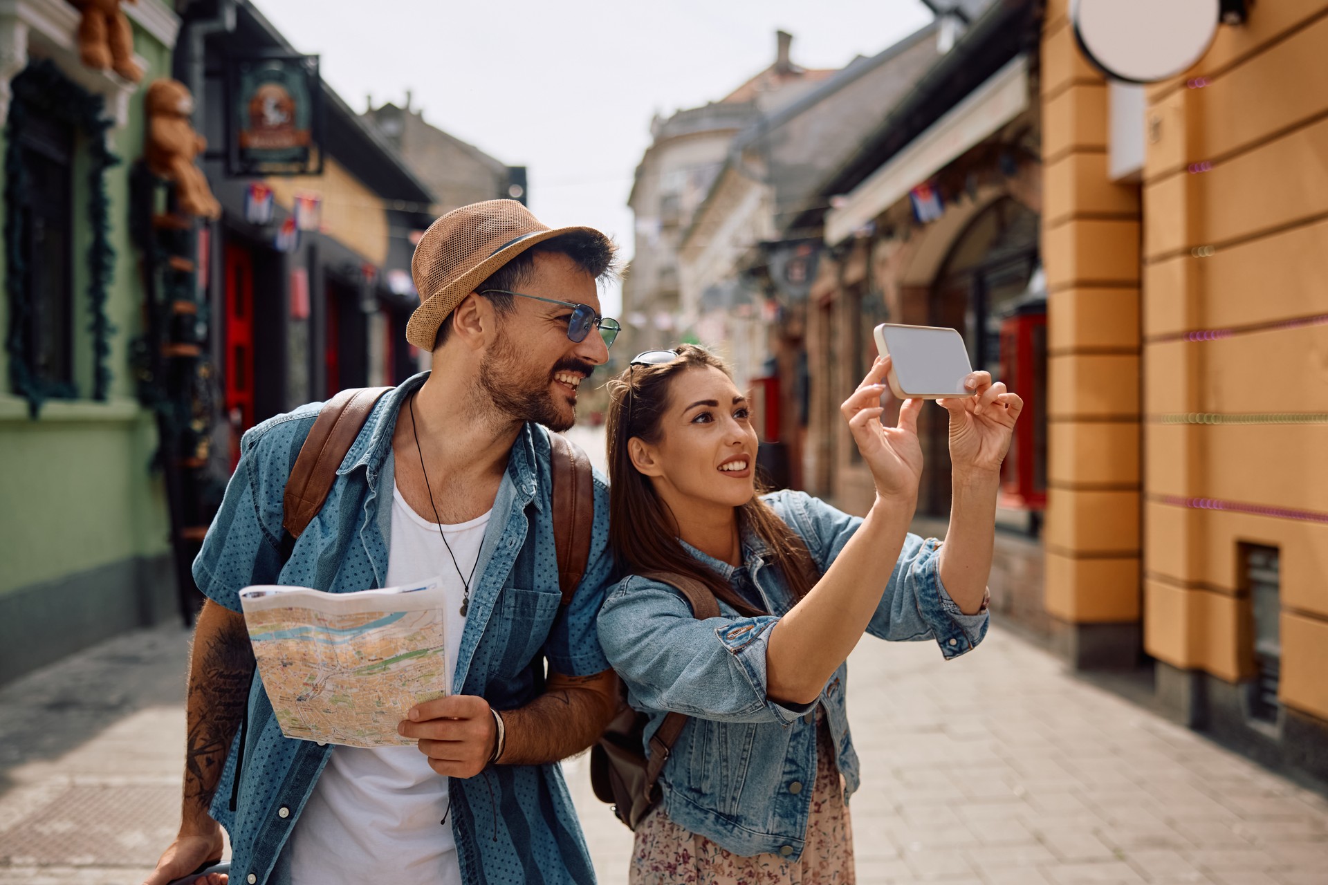 Happy tourist couple taking selfie while exploring the city.